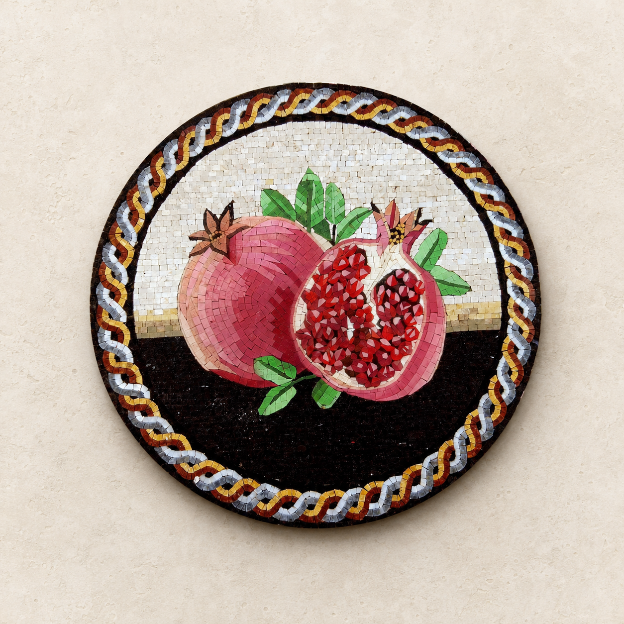 Round mosaic medallion of pomegranates made from individual stone tesserae, showing the hand-cut detail of each piece